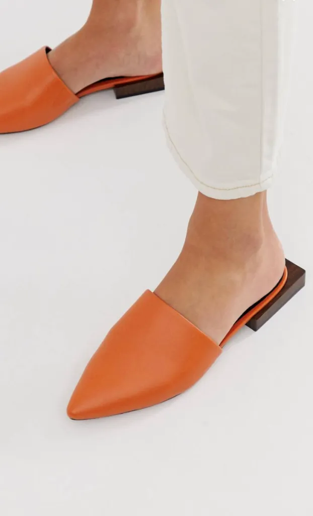 Стильные оранжевые мюли с маленьким геометричным каблуком.