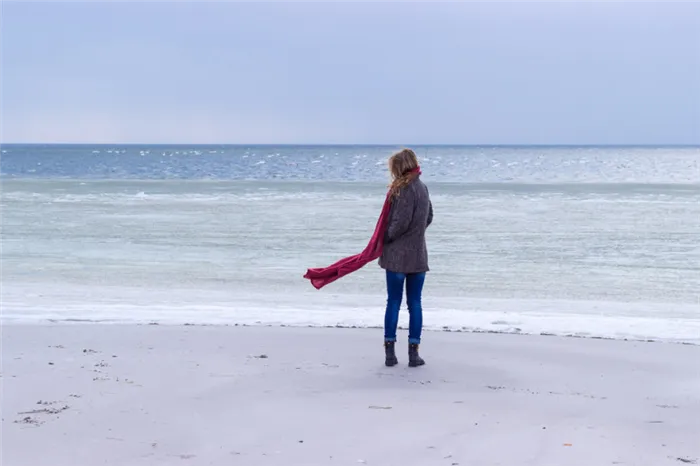 Девушка с депрессией на фоне холодного моря
