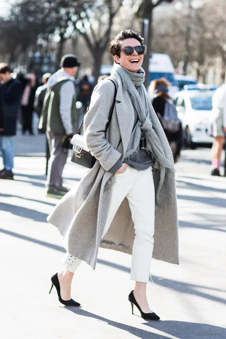 Девушка в длинном пальто и белых брюках