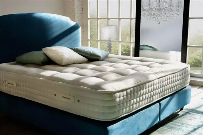 Кровать с большим толстым матрасом в спальной комнате