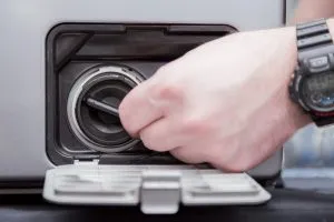 Фильтр сливного насоса расположен в нижней части передней панели стиральной машины