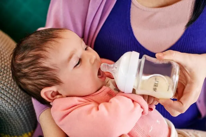 Ребенка кормят из бутылочки. С помощью бутылочки Philips Avent вы можете кормить ребенка предварительно законсервированным грудным молоком.