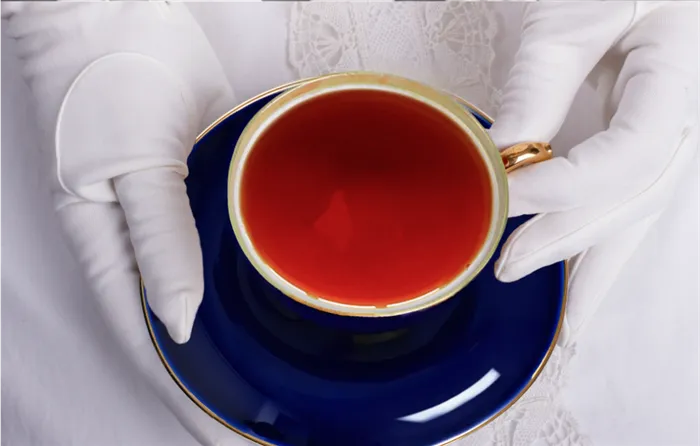 Чашка ароматного английского чая в руке женщины