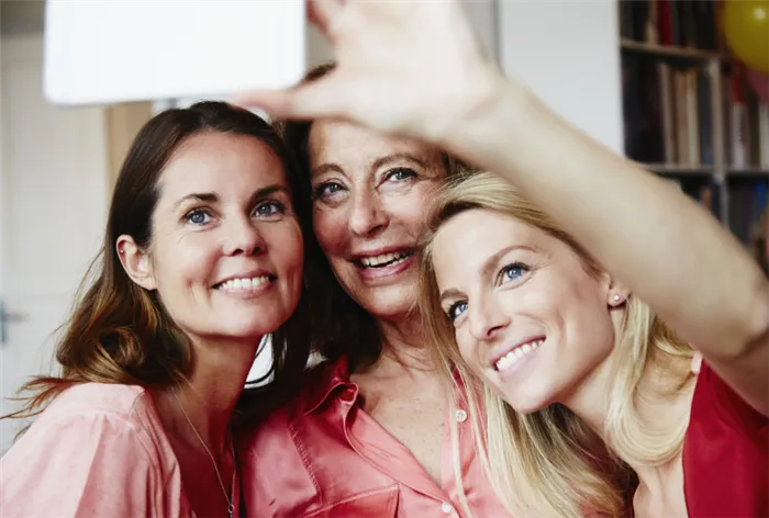 Три женщины разного возраста улыбаются в кадре