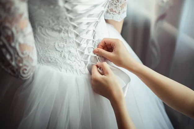 Bridesmaid делает bow-knot на задней части свадебного платья невест