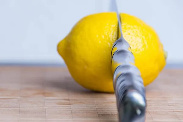 Нож и лимон на разделочной доске