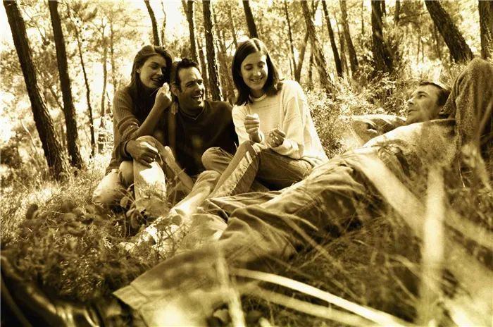 Желтое монохромное изображение группы друзей, сидя в лесу вместе.