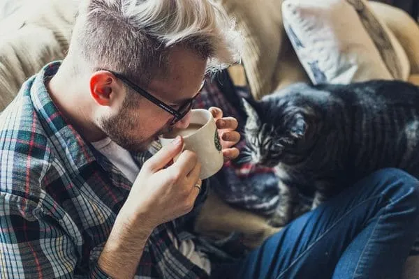 Мужчина с кофе и котом
