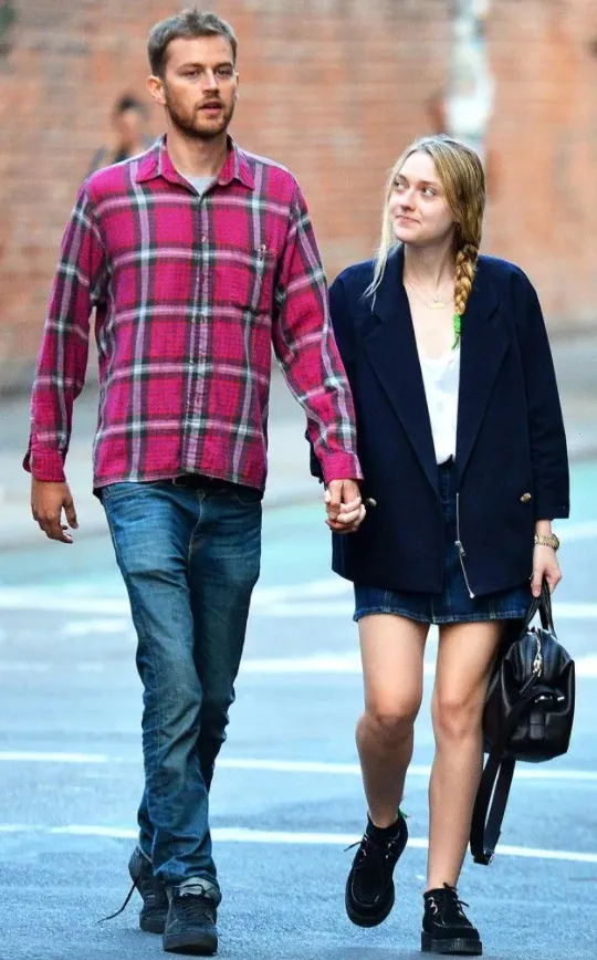 Актриса Дакота Фаннинг и ее парень идут по улице взявшись за руки.