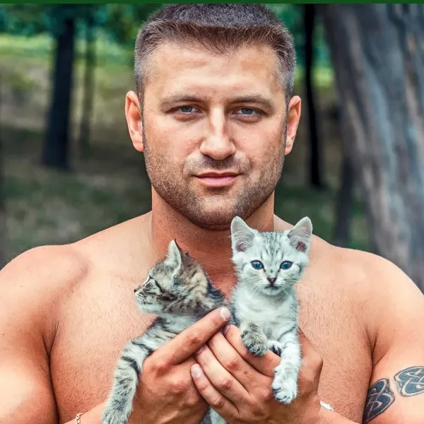 мужчина-Кабан держит котят на руках