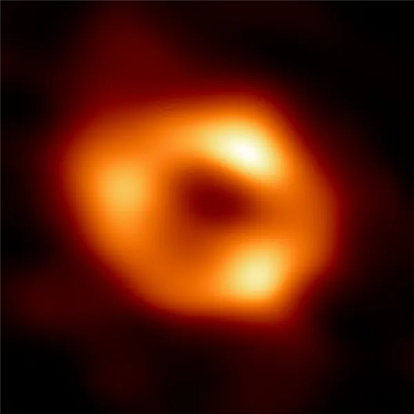 Сверхмассивная черная дыра в Стрельце А*, полученная с помощью телескопа Event Horizon в радиоволнах. Центральное темное пятно - это тень черной дыры, которая больше горизонта событий.