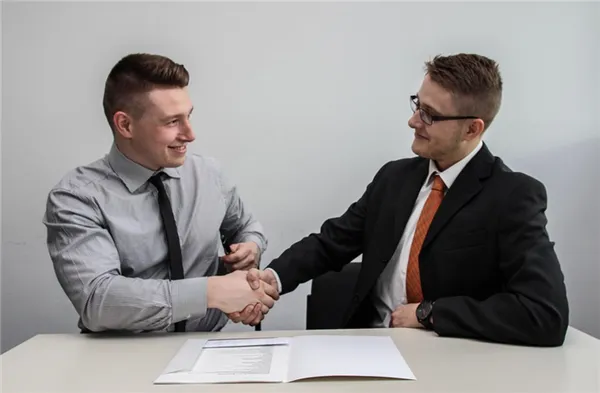 Мужчины обмениваются рукопожатием при деловых переговорах