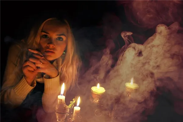 Девушка сидит у горящих свечей